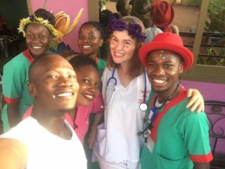 Majda Kočičí v ugandskej nemocnici - fotí sa s niekoľkými lekármi a sestrami. Má na krku fonendoskop.