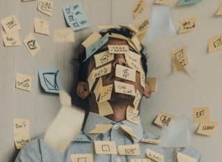 Fotografia muža oblepeného post-it papierikmi, čo symbolizuje stres.