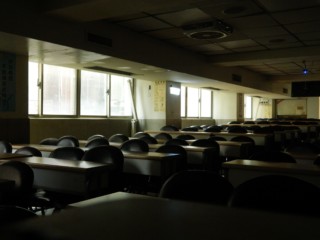 Fotografia prázdnej triedy. Zobrazuje veľa stoličiek a stolov.